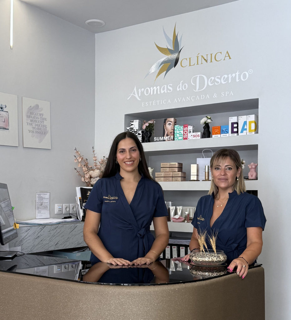 Equipa da Clínica Aromas do Deserto na receção, sob o logótipo da clínica